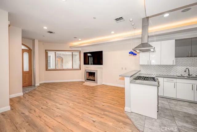 a kitchen with kitchen island a stove a sink and a refrigerator with wooden floor
