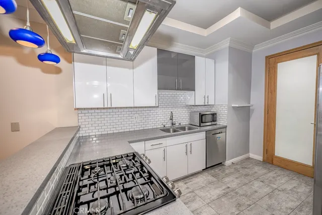 a kitchen with granite countertop a sink stove and cabinets