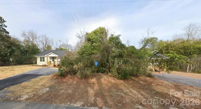a front view of a house with a yard and trees