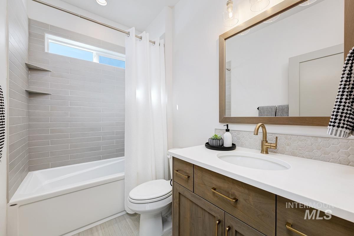 5817 South Gustav Avenue Meridian, ID 83642 - Photo 23 of 33 Bathroom featuring a wood-finish vanity with a white countertop, an undermount sink, and a framed mirror