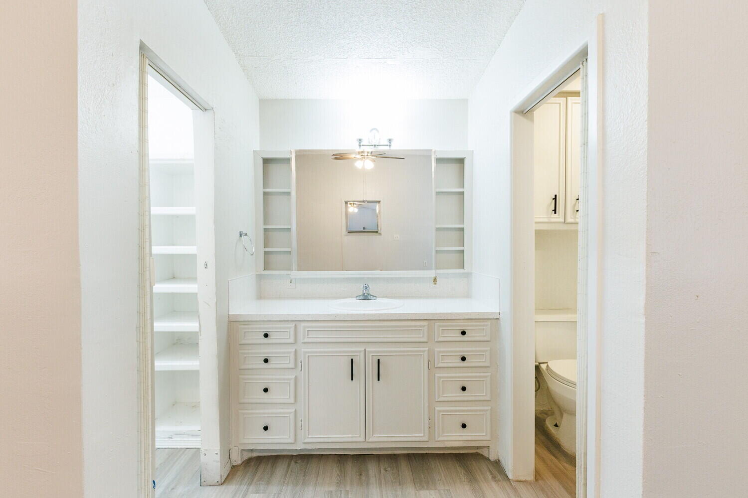 4402 44th Street Lubbock, TX 79414 - Photo 16 of 34 a bathroom with a granite countertop sink a toilet and a mirror