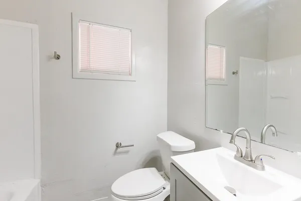 a bathroom with a sink a toilet and a mirror