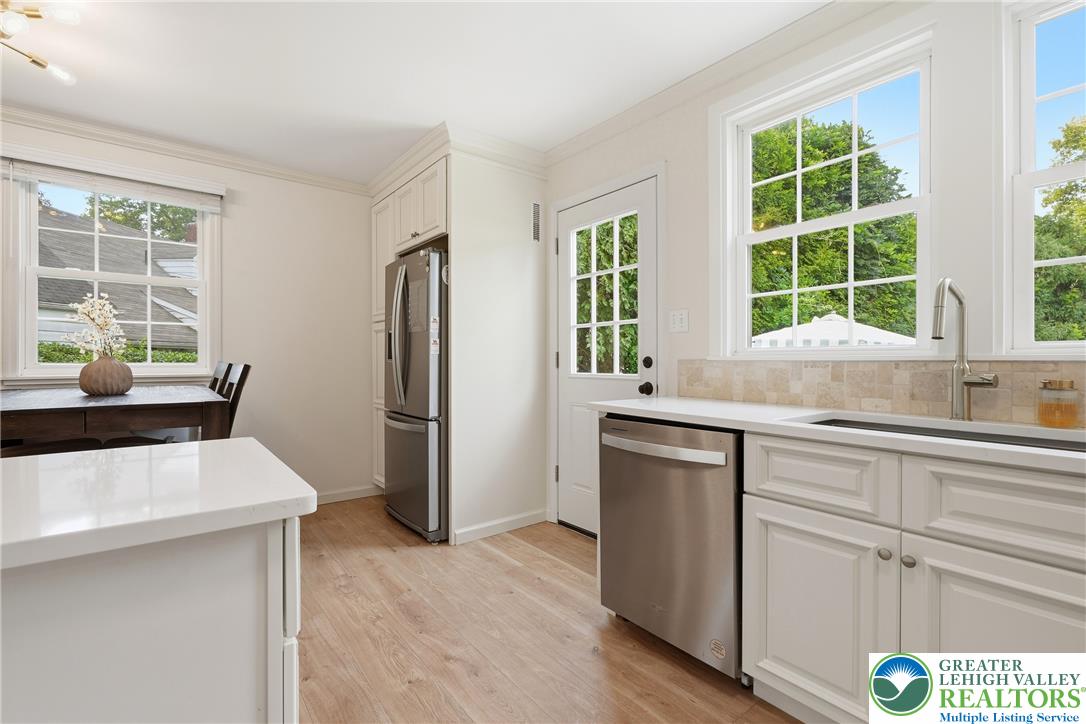 408 Maple Road Hellertown, PA 18055 - Photo 18 of 66 Gleaming stone countertops and classic wood flooring elevate this well-appointed culinary space.
