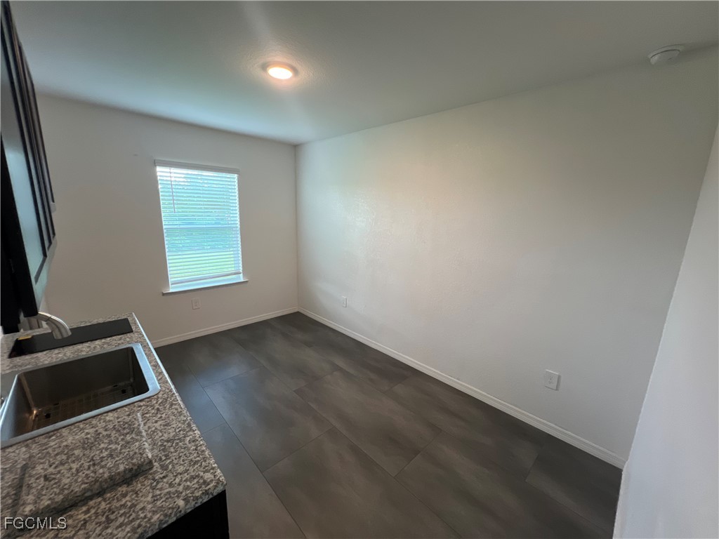 4301 17th Street Southwest Lehigh Acres, FL 33976 - Photo 2 of 7 an empty room with wooden floor and windows