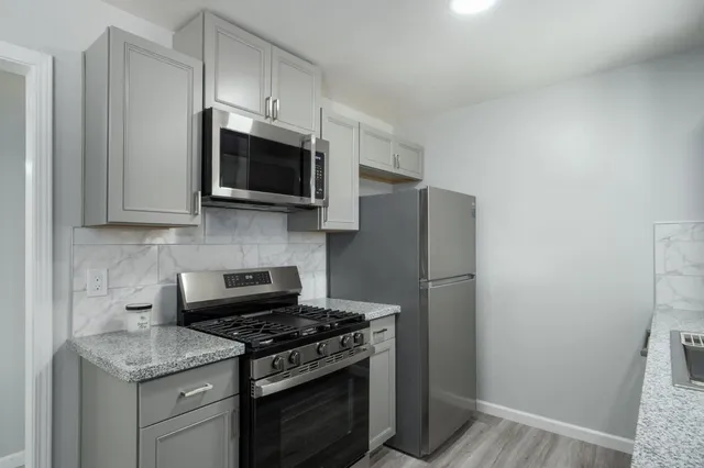 a kitchen with stainless steel appliances a stove microwave and refrigerator