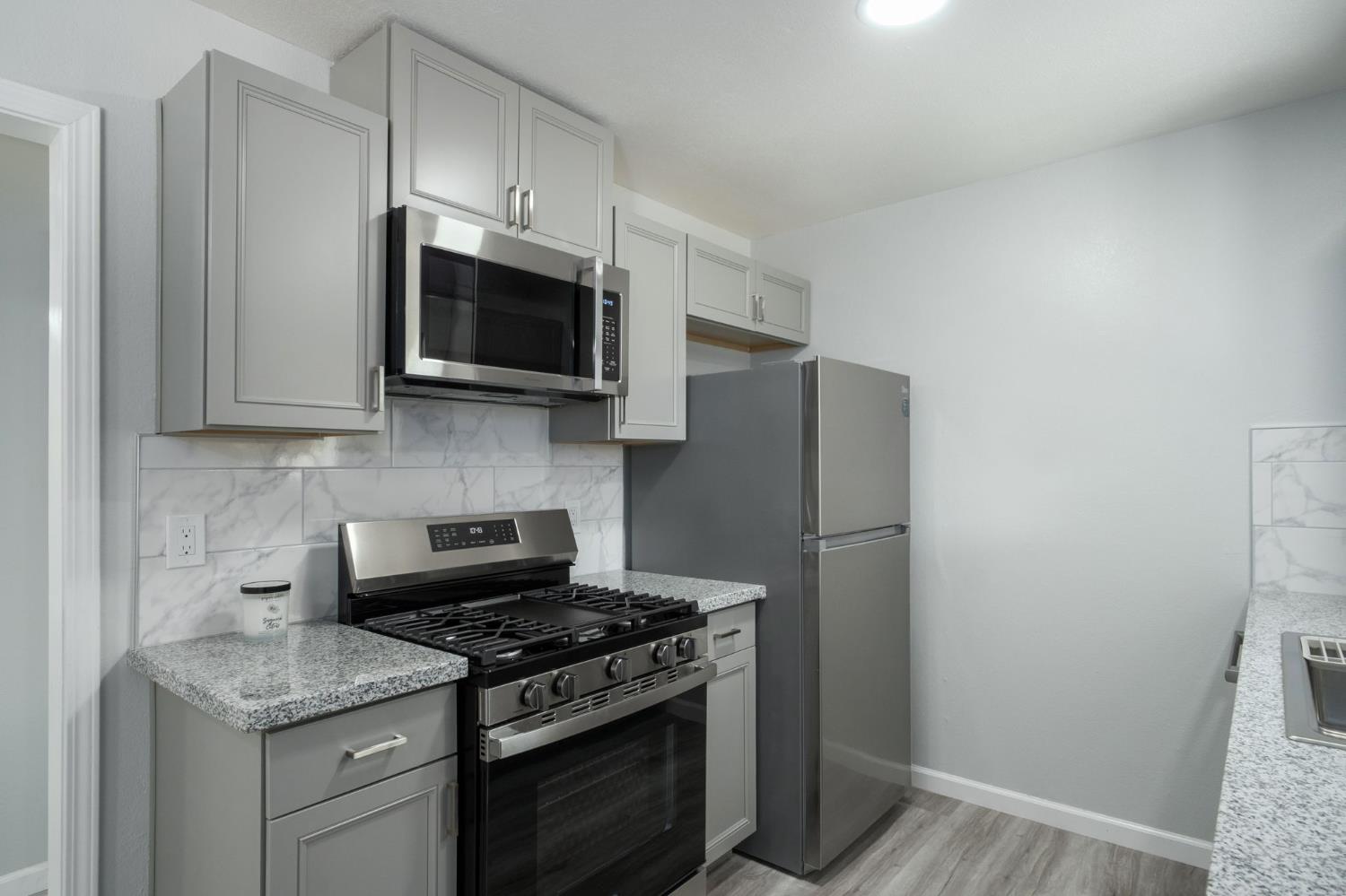 3062 Jasper Street Selma, CA 93662 - Photo 13 of 26 a kitchen with stainless steel appliances a stove microwave and refrigerator
