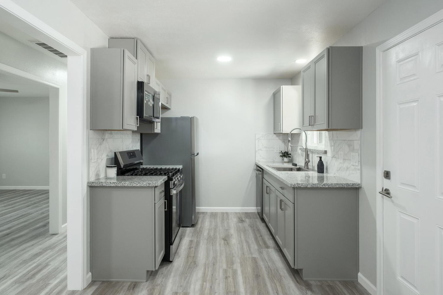 3062 Jasper Street Selma, CA 93662 - Photo 14 of 26 a kitchen with stainless steel appliances granite countertop a sink stove and refrigerator