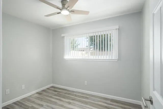 an empty room with a window and ceiling fan