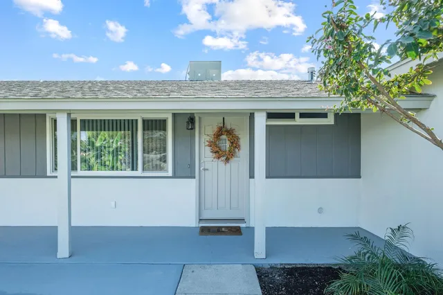 a view of a door of the house with a tree