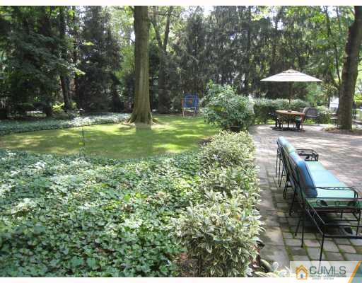 58 Pennington Road New Brunswick, NJ 08901 - Photo 4 of 10 a view of a garden with a bench under an umbrella