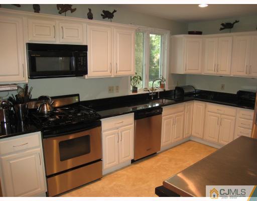 58 Pennington Road New Brunswick, NJ 08901 - Photo 8 of 10 a kitchen with granite countertop white cabinets and black appliances