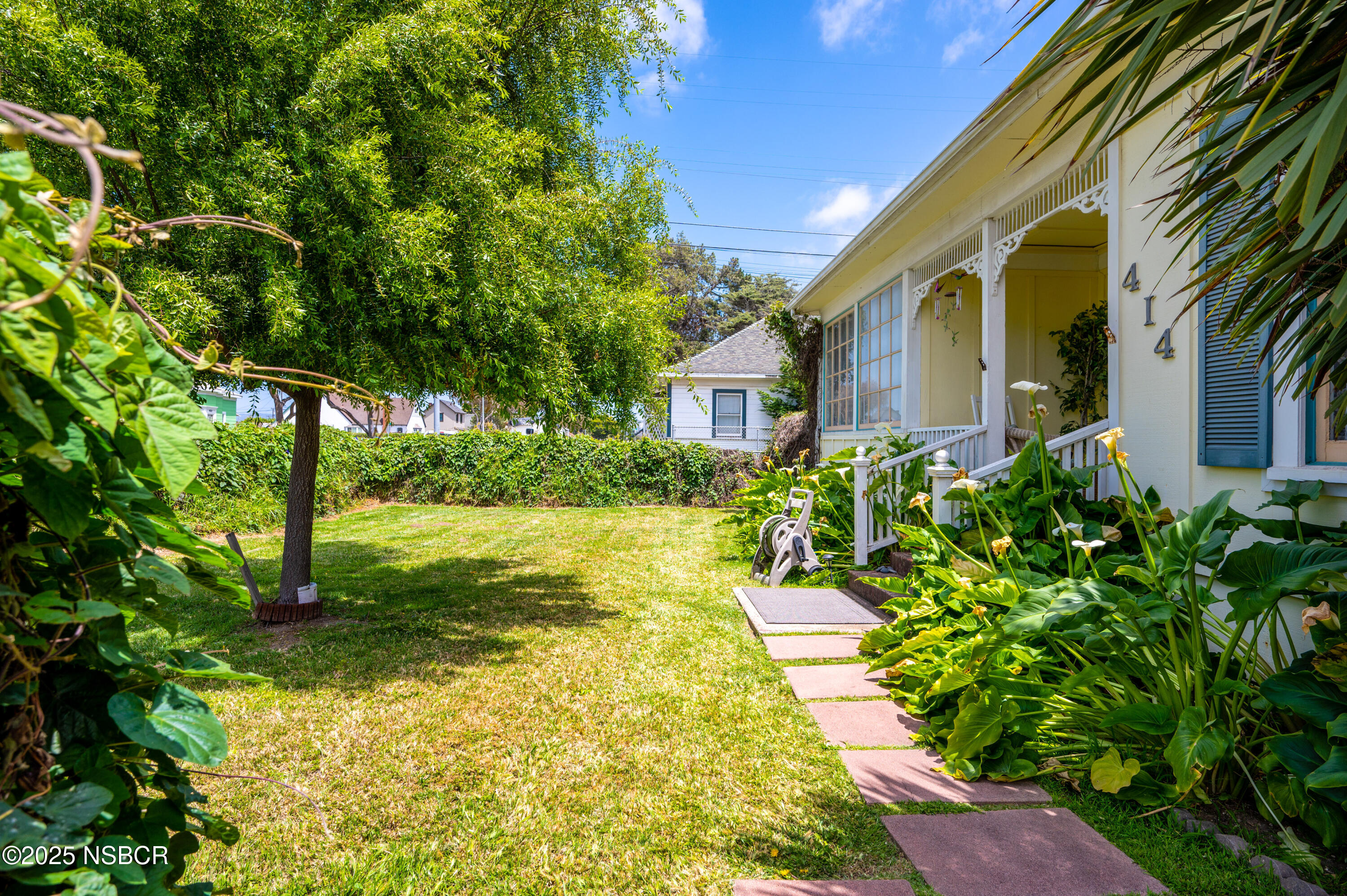 414 West Walnut Avenue Lompoc, CA 93436 - Photo 2 of 17 a yellow house with garden in front of it