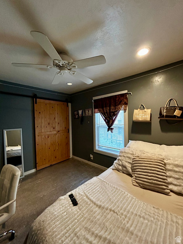 1931 Harrison Boulevard Ogden, UT 84401 - Photo 7 of 21 Bedroom #2 Spacious room featuring a natural wood barn door, window with white trim, and a ceiling fan