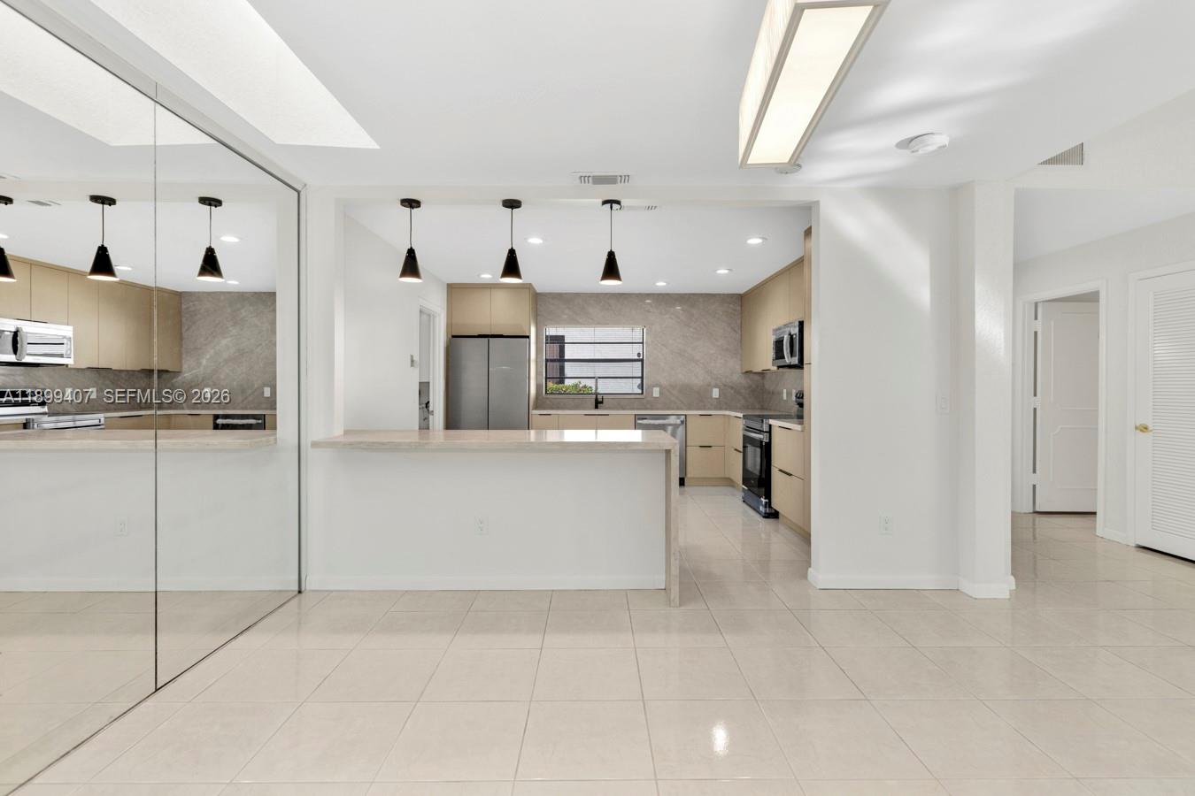 21686 Arriba Real, Unit 40A Boca Raton, FL 33433 - Photo 11 of 53 a kitchen with kitchen island white cabinets and refrigerator