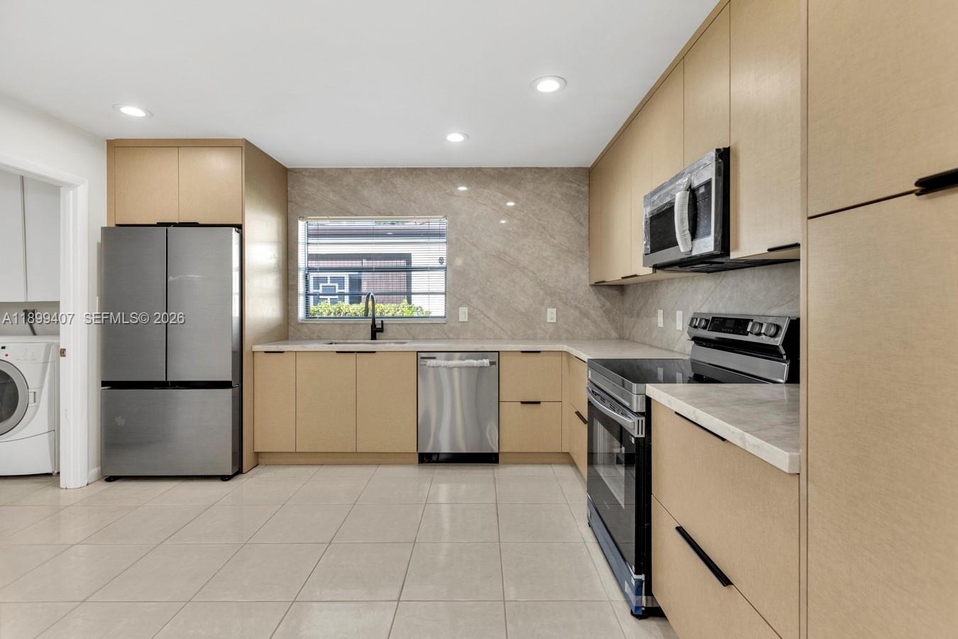 21686 Arriba Real, Unit 40A Boca Raton, FL 33433 - Photo 12 of 53 a kitchen with a sink a refrigerator and a stove top oven with wooden floor