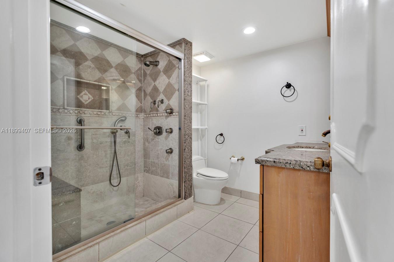 21686 Arriba Real, Unit 40A Boca Raton, FL 33433 - Photo 26 of 53 a bathroom with a granite countertop shower a toilet and a sink