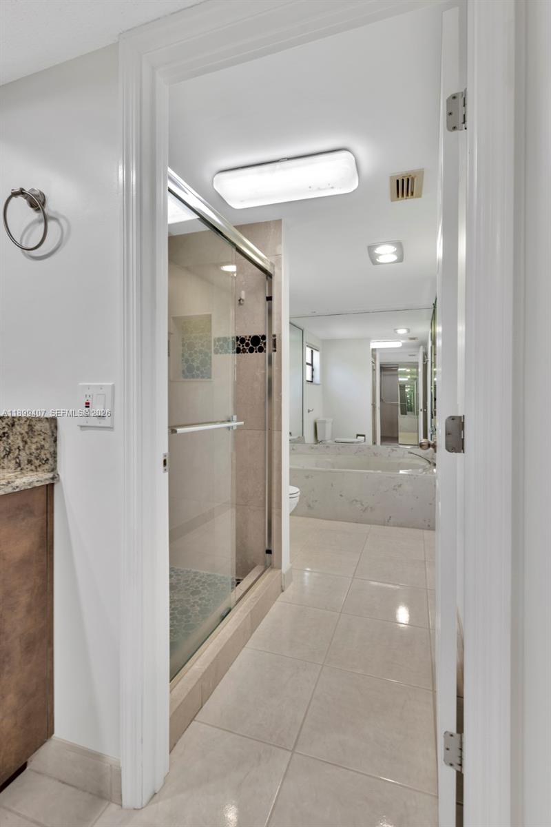 21686 Arriba Real, Unit 40A Boca Raton, FL 33433 - Photo 34 of 53 a bathroom with a glass shower door and a mirror