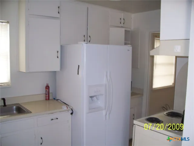 a kitchen with a refrigerator and a sink