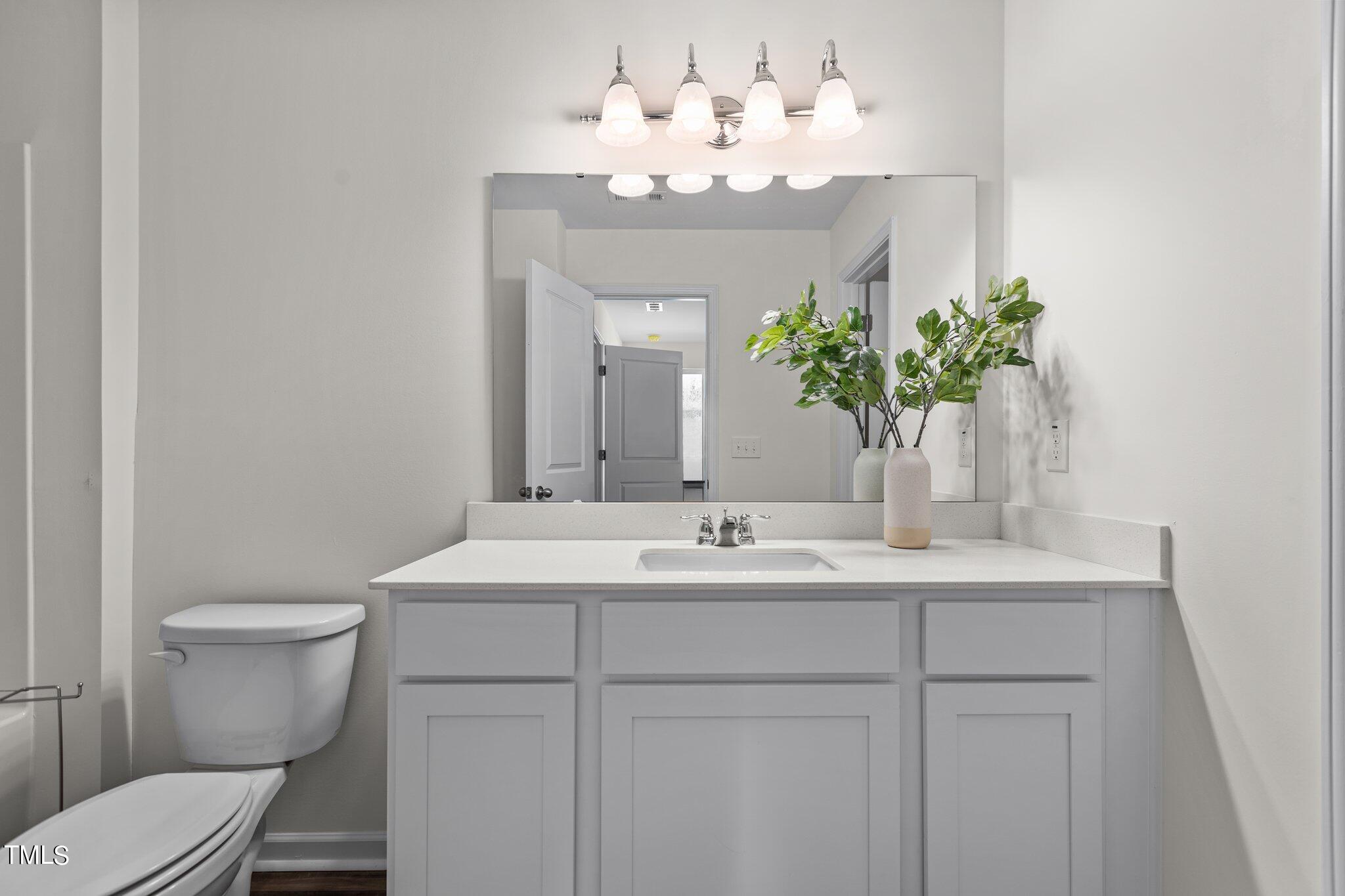 130 South Chubb Ridge Clayton, NC 27520 - Photo 23 of 32 a bathroom with a sink a toilet and a mirror