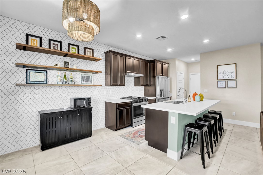 9688 Rankin Rdg Court Las Vegas, NV 89178 - Photo 16 of 53 Culinary aspirations come alive in this kitchen, featuring an inviting island and stylish open shelving.