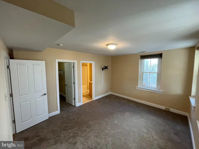 an empty room with windows and closet