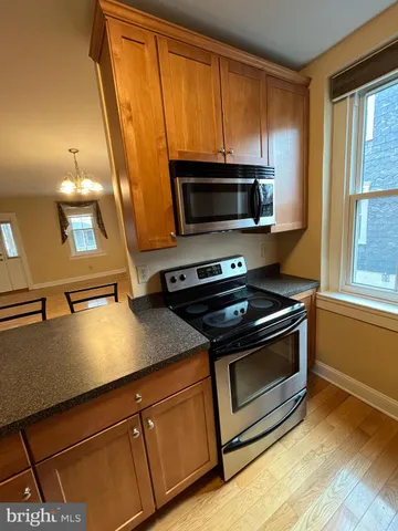 a kitchen with granite countertop a stove microwave and sink