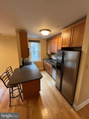 a kitchen with stainless steel appliances granite countertop a refrigerator a stove a sink dishwasher with a dining table and chair with wooden floor