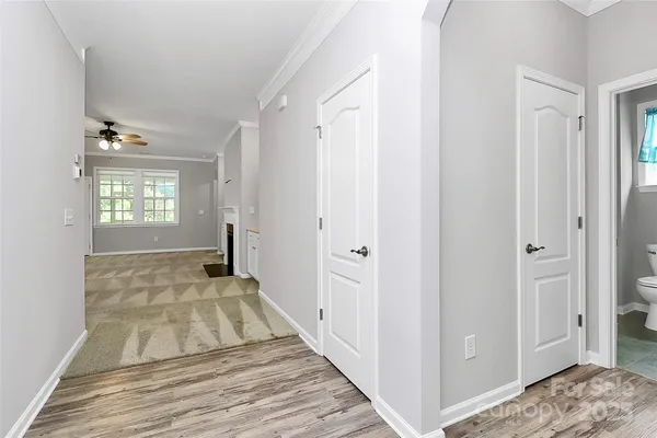 a view of a bedroom with wooden floor and windows