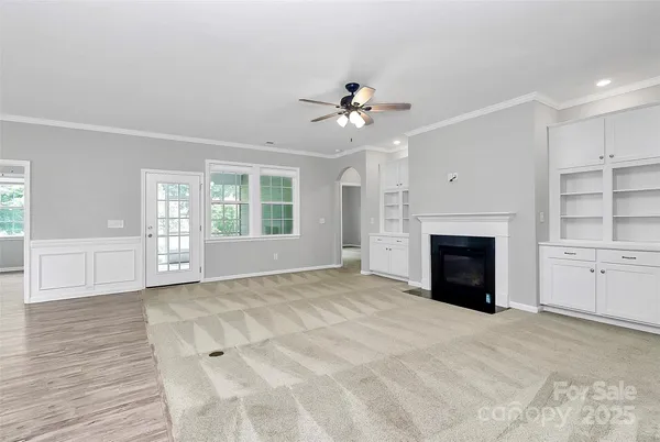 a view of an empty room with a fireplace and a window