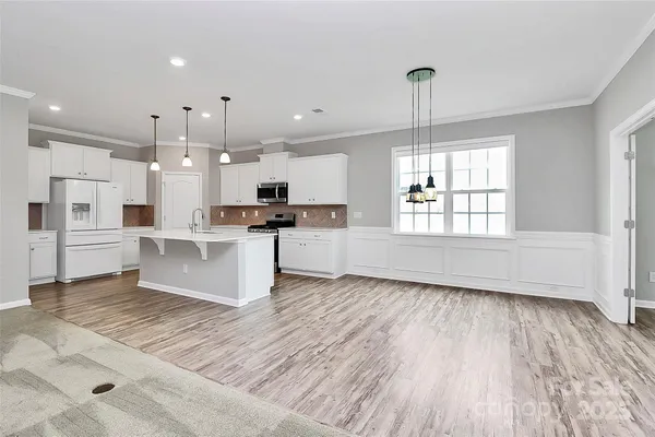 a large kitchen with granite countertop a stove top oven a sink a counter space and cabinets