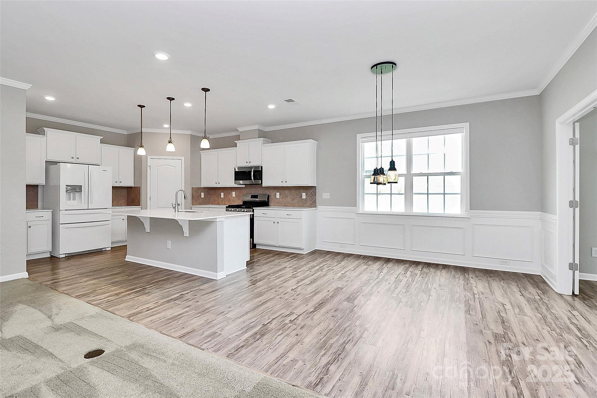 5149 Samoa Ridge Drive Lancaster, SC 29720 - Photo 19 of 40 a large kitchen with granite countertop a stove top oven a sink a counter space and cabinets