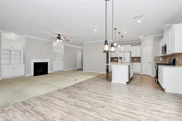 a view of a kitchen with a sink stove cabinets and stainless steel appliances