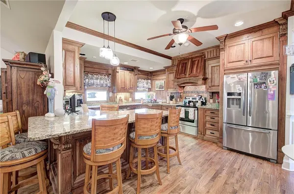 a kitchen with stainless steel appliances granite countertop a refrigerator and a stove