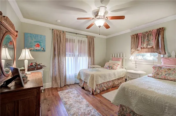 a bedroom with a bed a chandelier and dresser