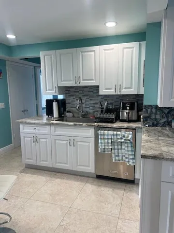a kitchen with stainless steel appliances a sink a stove a microwave and cabinets