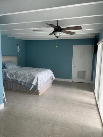 a bedroom with a bed and a ceiling fan