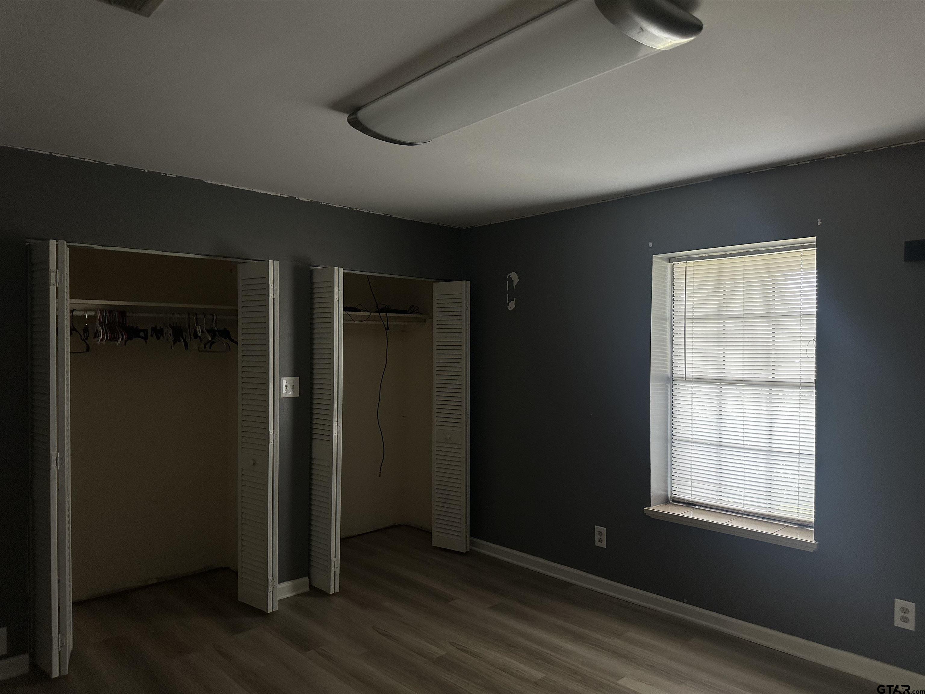 141 Meador Road Kilgore, TX 75662 - Photo 11 of 14 an empty room with wooden floor and windows