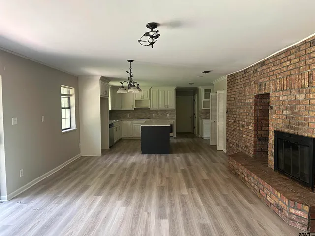 a large kitchen with cabinets wooden floor and stainless steel appliances