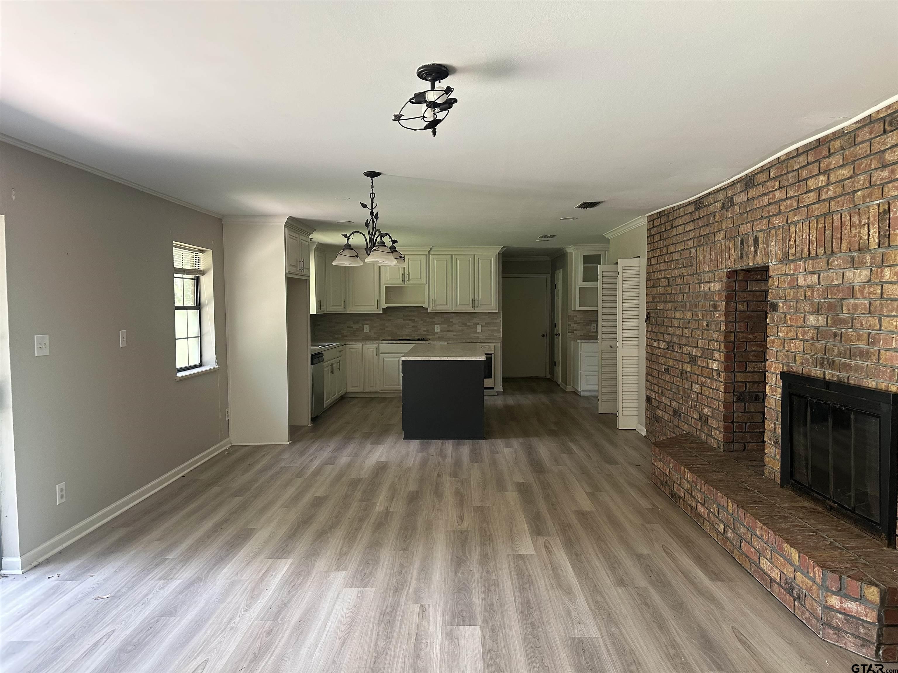 141 Meador Road Kilgore, TX 75662 - Photo 3 of 14 a large kitchen with cabinets wooden floor and stainless steel appliances