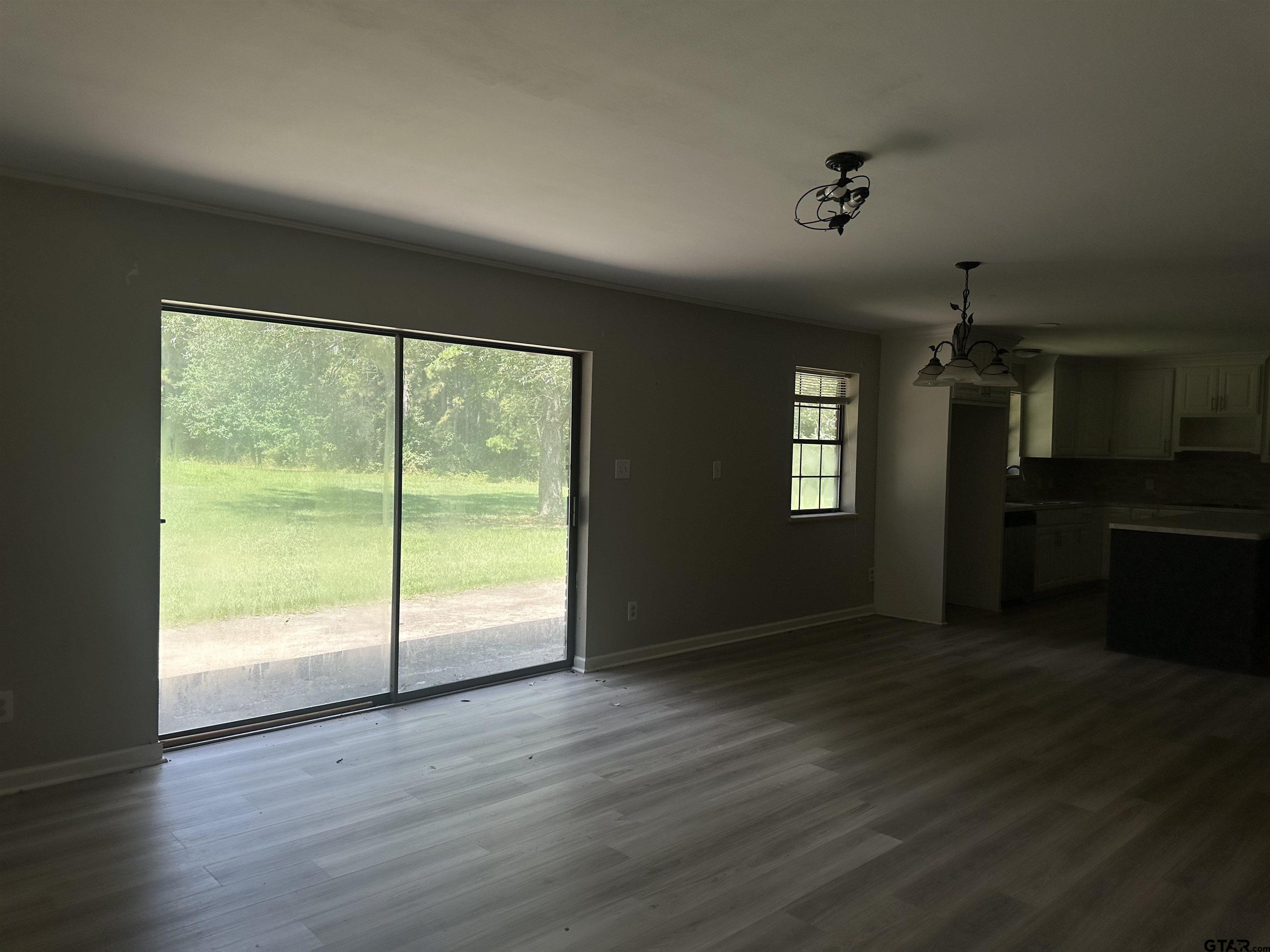 141 Meador Road Kilgore, TX 75662 - Photo 4 of 14 a view of an empty room with wooden floor and a window