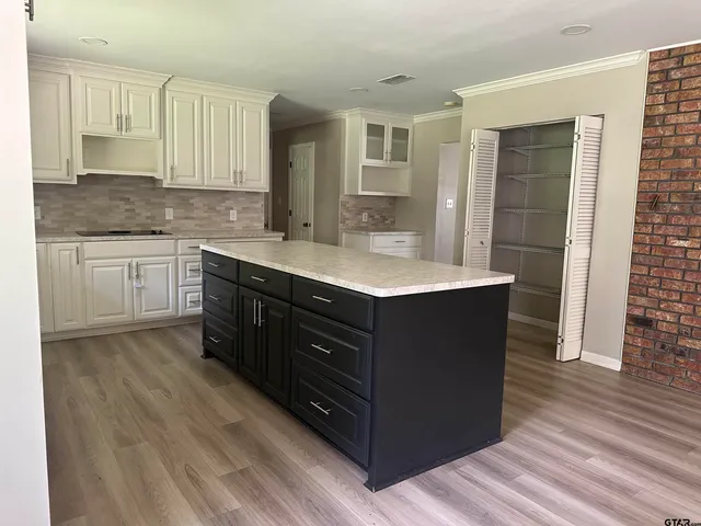 a spacious bathroom with a granite countertop sink a mirror and a bathtub