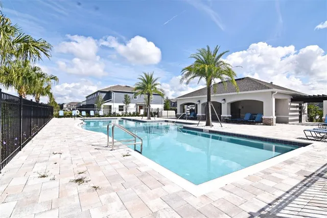 a view of a house with swimming pool and sitting area