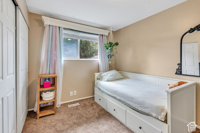 892 Bear Canyon Road Sandy, UT 84094 - Photo 12 of 36 Carpeted room featuring a white paneled bed frame with integrated storage, a window with a valance, and a bi-fold closet door