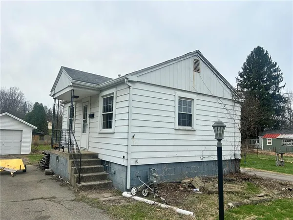 a view of a house with a yard and sitting area