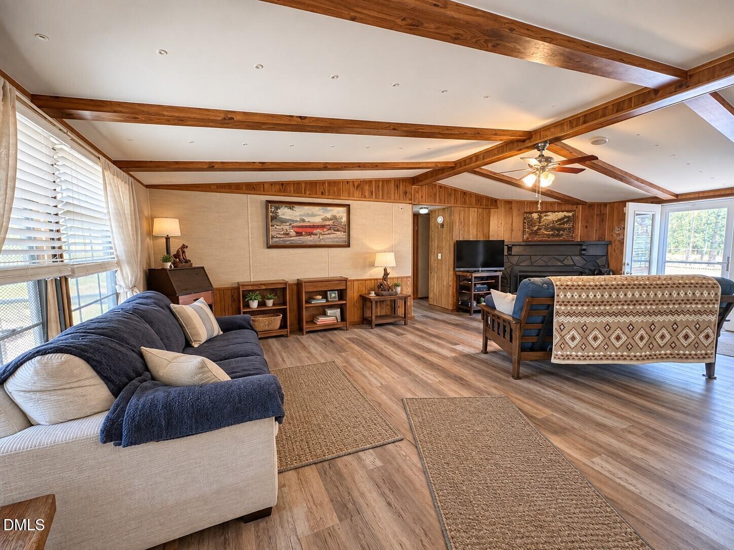 471 Kramer Road Lillington, NC 27546 - Photo 5 of 26 Wood-finish flooring throughout the living area, complemented by wood paneling and exposed wood beams