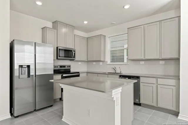 a kitchen with cabinets stainless steel appliances and a counter space