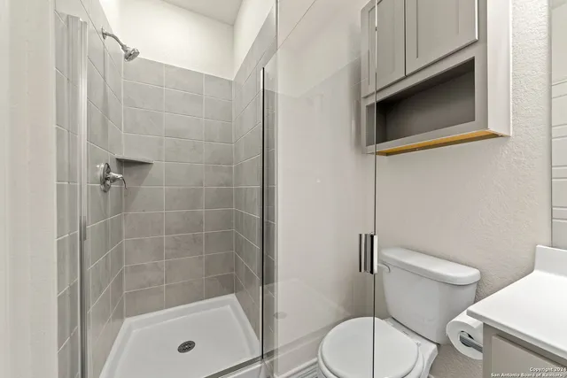 a bathroom with a toilet and a shower