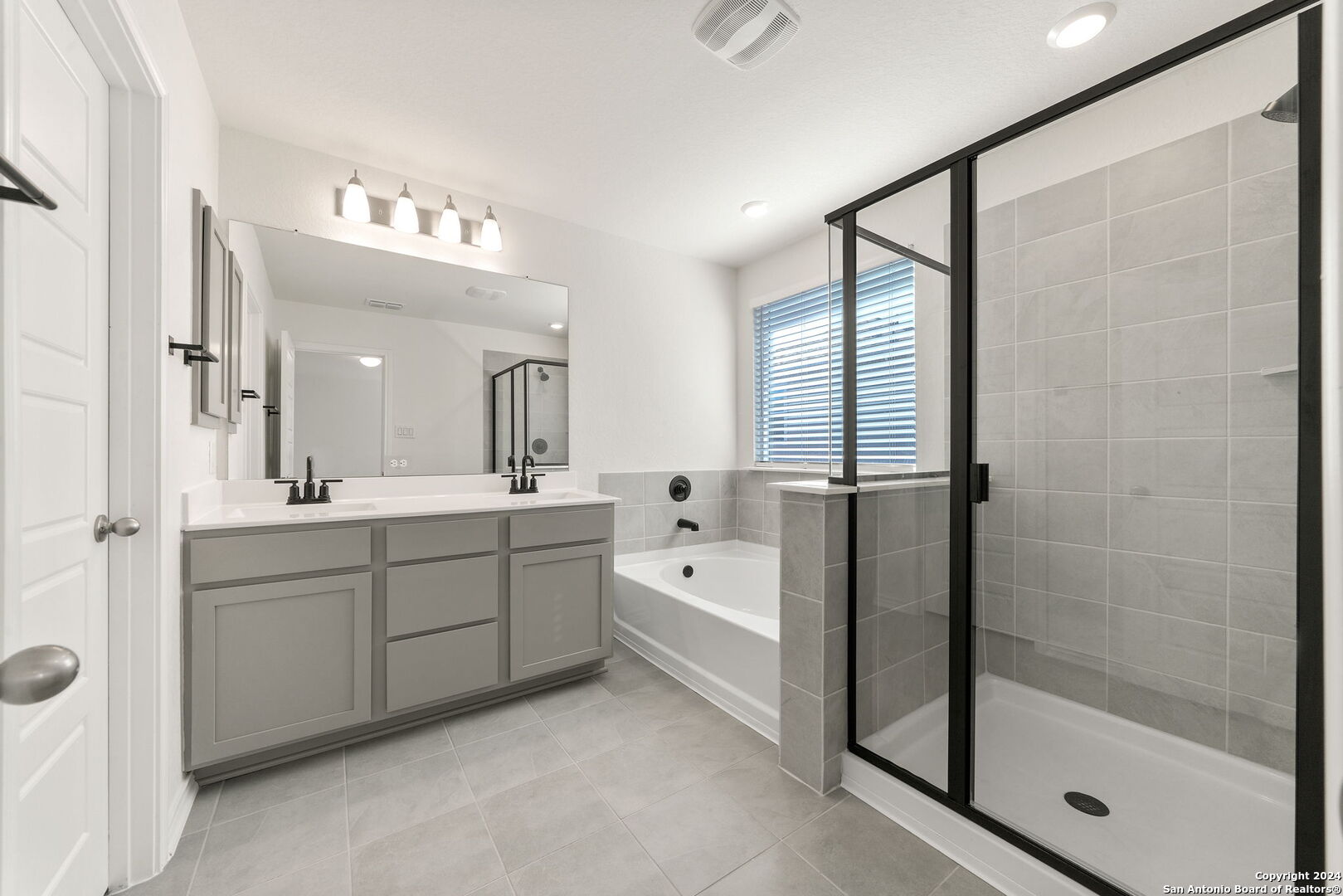 14839 Vance Jackson Road, Unit 910 San Antonio, TX 78249 - Photo 19 of 29 a spacious bathroom with a shower sink and mirror