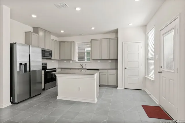 a kitchen with a refrigerator sink and cabinets