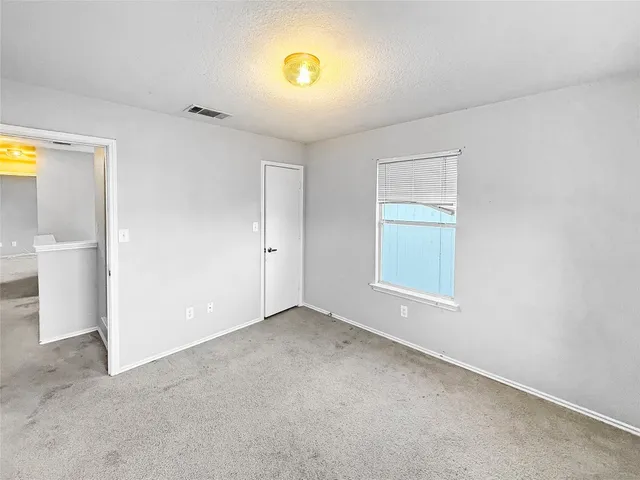 an empty room with windows and closet